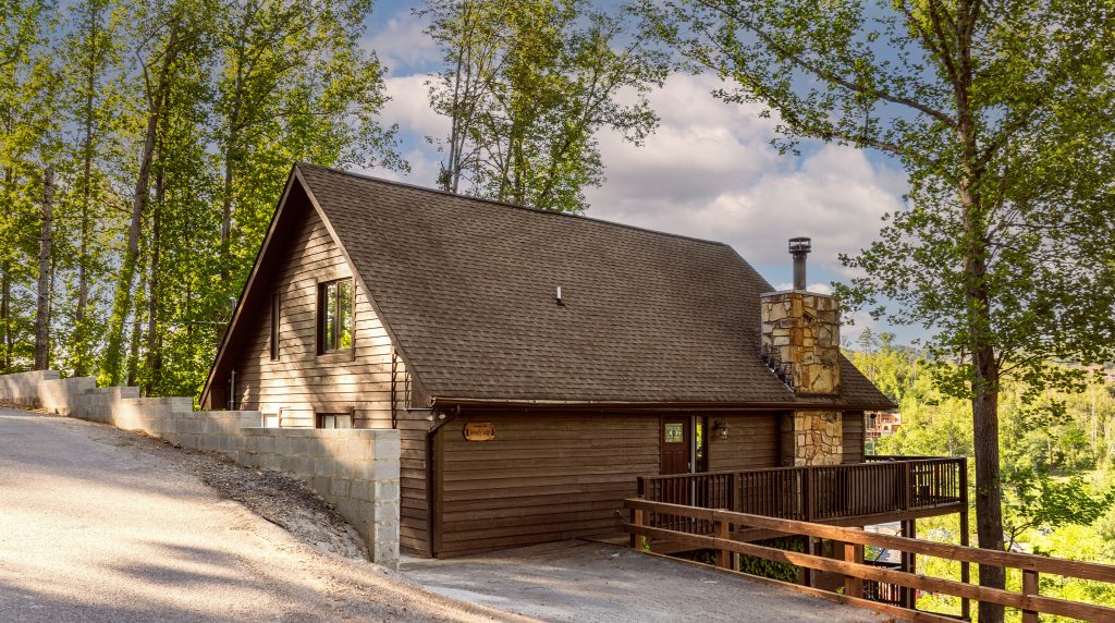 Rustic wooden cabin surrounded by trees near Gatlinburg TN vacation rentals.